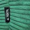 A close-up of a green corduroy fabric with a black label attached. Náhled obrázku produktu