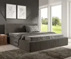 A modern bedroom with a large bed and a view of a garden through the windows. Náhled obrázku produktu