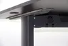 A close-up view of the underside of a black desk, showing the mounting bracket and cable management system. Anteprima dell’immagine prodotto