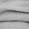 A close-up view of a folded, textured gray fabric. Náhľad obrázku produktu