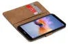 A brown book-style phone case with a smartphone inside, showing the screen and two credit cards in a slot. Anteprima dell’immagine prodotto