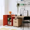 A modern home office setup with a bright orange metal cabinet and a wooden desk. Voir les images du produit