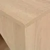 A close-up view of the corner of a wooden table or cabinet with a light oak finish. Podgląd zdjęcia produktu