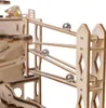 A close-up view of a wooden marble run toy with several silver marbles on its tracks. Voir les images du produit