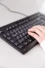 A person's hand is typing on a black keyboard. Náhľad obrázku produktu