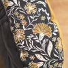 A close-up view of a cushion with a floral pattern. Produktbild-Vorschau