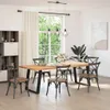 A dining room scene with a wooden table and chairs, a large window with greenery outside, and a bookshelf. Voir les images du produit