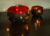 Two decorative bowls filled with red material and illuminated by fairy lights. Voir les images du produit