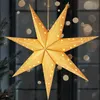 A golden star-shaped lantern with small white stars, hanging in front of a window with bokeh lights. Podgląd zdjęcia produktu