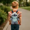 A young child walks away from the camera wearing a Stitch backpack. Voir les images du produit