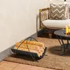 An outdoor patio setting with a firewood rack, a chair with a pillow, and a fire pit. Produktbild-Vorschau