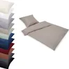 A stack of folded bedding in various colors and a single bedding set laid out. Produktbild-Vorschau