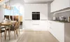 A modern, minimalist kitchen with white cabinets, an integrated oven, and a dining area with a wooden table and chairs. Produktbild-Vorschau