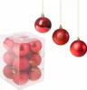 A box of red Christmas ornaments and three hanging red Christmas ornaments. Náhled obrázku produktu