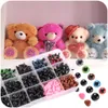 A collection of craft safety eyes and noses in a divided plastic case, with several teddy bears in the background. Náhled obrázku produktu