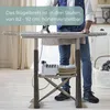 A person is ironing clothes on an adjustable ironing board in a well-lit room. Produktbild-Vorschau