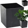 A large black planter with a textured finish is shown in the foreground, with a smaller black planter and a green plant in the background. The smaller planter is a close-up view of the product. Produktbild-Vorschau