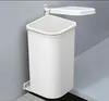 A white trash can with a lid is mounted on a gray wall. Produktbild-Vorschau