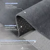 A close-up view of a folded gray rug, showing its soft surface and anti-slip bottom. Produktbild-Vorschau