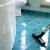 A bathroom floor being cleaned with a vacuum cleaner. Náhled obrázku produktu