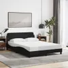 A bedroom scene with a black bed frame and white mattress. Podgląd zdjęcia produktu