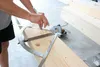 A person is using a protractor and ruler to measure a wooden beam. Anteprima dell’immagine prodotto