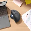 A Logitech ERGO M575 Trackball mouse is shown on a wooden desk next to a laptop and some papers. Anteprima dell’immagine prodotto