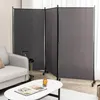 A three-panel room divider with a gray fabric surface and black metal frame is set up in a living room, partially obscuring a sofa and a small table. Náhľad obrázku produktu