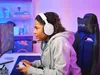 A young person wearing headphones and playing a video game. Anteprima dell’immagine prodotto