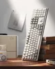 A keyboard is displayed on a wooden desk with books and a vintage computer. Produktbild-Vorschau