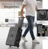 A person is walking with a black suitcase in what appears to be an airport or large indoor public space. Inset images highlight product features. Produktbild-Vorschau