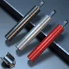 Three safety hammers in different colors are displayed diagonally on a dark textured surface, with a small metal holder in the foreground. Produktbild-Vorschau