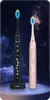 Two electric toothbrushes, one black and one rose gold, are displayed against a starry night background with clouds. Náhled obrázku produktu