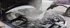 Person cleaning a car engine with a steam cleaner. Náhled obrázku produktu
