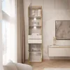 A modern living room with a tall glass display cabinet filled with decorative items, next to a wall-mounted cabinet and a large framed artwork. Produktbild-Vorschau