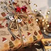 A close-up of a Christmas gift wrapped in festive paper, adorned with a wooden angel and red star ornaments. Twine is used to tie the gift. Produktbild-Vorschau