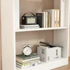 A white bookshelf with various items on its shelves, including books, a radio, and an alarm clock. Podgląd zdjęcia produktu