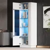 A modern white high-gloss display cabinet with blue LED lighting, showcasing books and decorative items on glass shelves. Produktbild-Vorschau