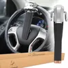 A steering wheel lock is shown attached to a car's steering wheel, with a separate view of the lock and its packaging box. Náhľad obrázku produktu