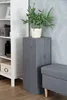 A plant stand with a potted plant on top, next to a bookshelf and a bench. Voir les images du produit