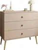 A beige dresser with three drawers and wooden legs, decorated with a lamp, candles, and flowers on top. Náhled obrázku produktu