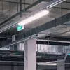 The image shows a ceiling with industrial lighting and ventilation systems, typical of a parking garage or warehouse. Anteprima dell’immagine prodotto