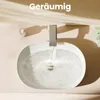 A close-up overhead view of a white oval washbasin with water running from a modern gray faucet. Anteprima dell’immagine prodotto