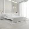 A minimalist bedroom setting with a white bed as the central focus. Náhled obrázku produktu