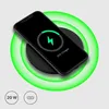 A black wireless charger with a smartphone on top, showing it is charging. Produktbild-Vorschau