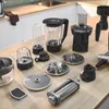 A collection of kitchen appliance attachments laid out on a wooden countertop. Produktbild-Vorschau