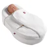 A baby doll is lying in a white baby cocoon or sleeping bag. Anteprima dell’immagine prodotto