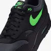 A close-up view of a black Nike Air Max 1 Essential sneaker with green accents. Produktbild-Vorschau