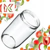A clear glass jar is shown at an angle, surrounded by various fresh vegetables and herbs. Podgląd zdjęcia produktu