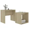 Two wooden cube-shaped tables, one larger than the other, are placed side-by-side against a white background. The larger table on the left has a plant and some office supplies on top. The smaller table on the right has books stacked inside it and a glass o Produktbild-Vorschau
